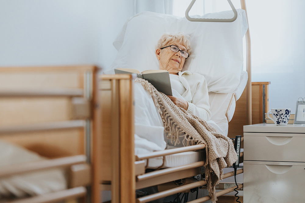 Alte Frau liegt ein einem Pflegebett